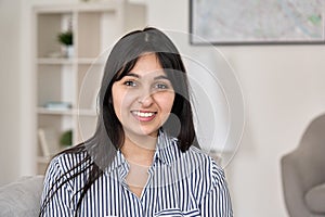 Portrait of young happy indian woman looking at camera at home office.