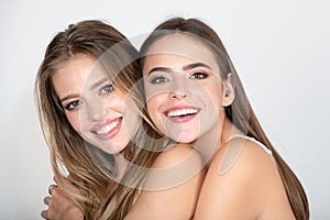 Portrait of young happy smiling models. Two girls with beautiful eyes, nice lips. Natural and healthy women. Perfect