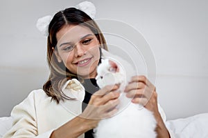 Portrait of young happy smiling woman holding cute white Persian cat, happy beautiful lady playing with fluffy pet, girl hugging
