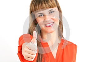 Portrait of young happy smiling woman showing thumbs up gesture, over grey background.