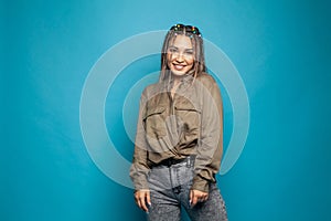 Portrait of young happy woman looks at camera on blue background