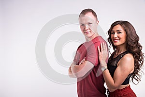 Portrait of young healthy sporty couple hugging on white background with copy space.