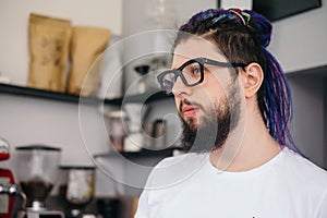 Portrait of young hipster man with dreadlocks in cafe