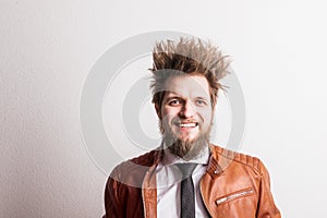 Portrait of a young hipster man with messy hairstyle in a studio. Copy space.