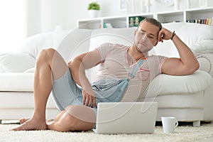 Portrait of a young hipster man spending time with laptop at home