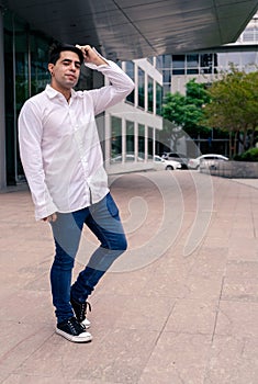 Portrait of a young Hispanic or Latino man at the entrance of a building. Modern Urban Concept