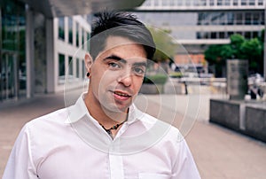Portrait of a young Hispanic or Latino man at the entrance of a building. Modern Urban Concept