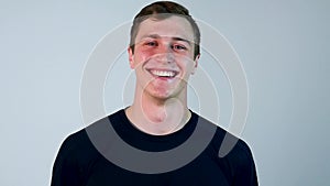 Portrait of young hispanic man with blue t-shirt, standing and laughing isolated on white background - laughter concept