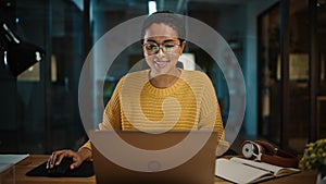 Portrait of Young Hispanic Marketing Specialist Working on Laptop Computer in Busy Creative Office