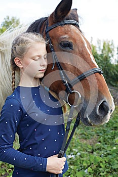 Portrait of young horsewoman and brown horse.