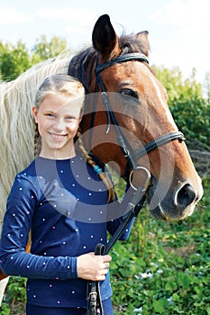 Portrait of young horsewoman and brown horse.