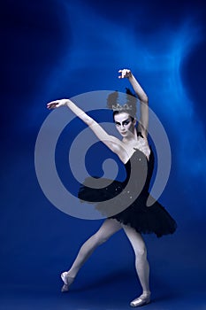 Portrait of young incredibly beautiful woman, ballerina in black ballet outfit, tutu dancing at blue studio full of