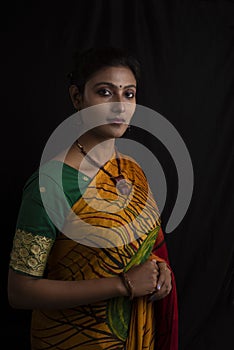 Portrait of young Indian Bengali brunette woman in Indian traditional wear sari