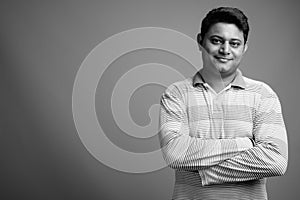 Portrait of young Indian man against gray background