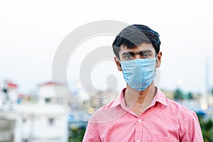 Portrait of young Indian man wearing surgical mask for protection from harmful virus and pollution