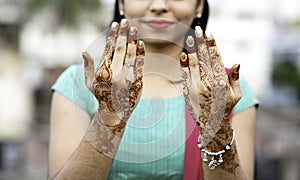 Portrait of a young Indian woman in casual style with mehendi or henna design on the both hands