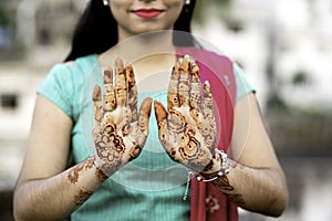 Portrait of a young Indian woman in casual style with mehendi or henna design on the both hands