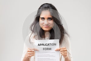 Portrait of young Indian woman holding application