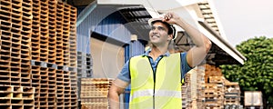 Portrait of young Indian worker working in logistic industry outdoor in front of factory warehouse. Smiling happy man