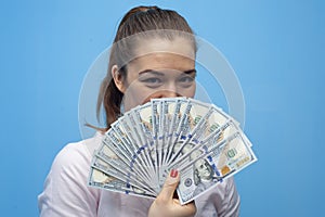 Portrait of young joyful business woman holding american dollars bills