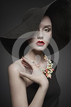 Portrait of young lady with black hat and evening dress