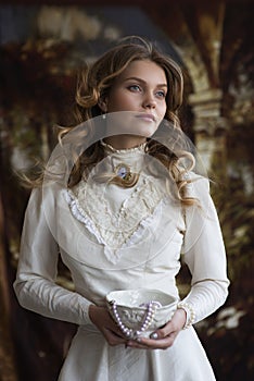 Portrait of a young lady in a white vintage dress