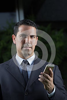 Portrait Of Young Latin Businessman Using Cell Phone photo