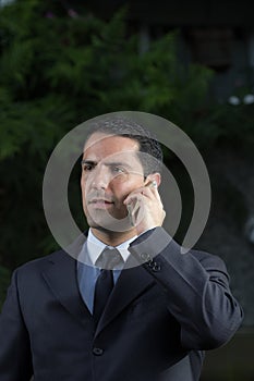 Portrait Of Young Latin Businessman Using Cell Phone photo