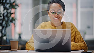 Portrait of Young Latin Marketing Specialist in Glasses Working on Laptop Computer in Busy Creative