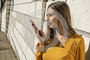 Portrait of a young Latin woman giving a funny message with her cell phone. Technology and communications concept