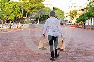 Portrait of a young Latino man with shopping bags in his hand