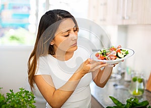 Portrait of young latino woman with fresh salad