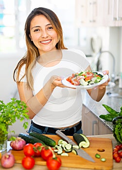 Portrait of young latino woman with fresh salad