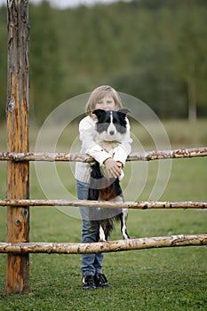 Portrait of a young little girl with dog breed border collie. Outdoors. Lifestyle