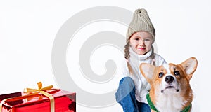 Portrait of young little girl with her pet puppy of corgi. Hugging near present. Concept christmas, new year and