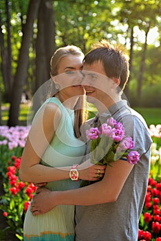 Portrait of a young in love couple near a field of tulips