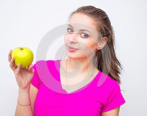Portrait of young lovely woman wearing in pink shirt with green apple
