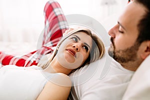 Portrait of young loving couple in bedroom