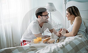 Portrait of young loving couple in bedroom