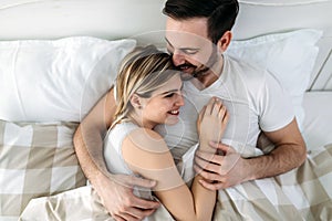 Portrait of young loving couple in bedroom