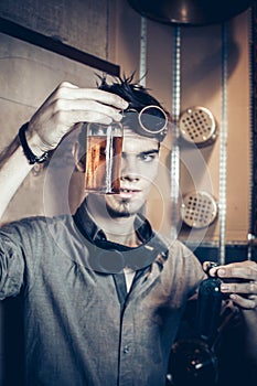 Portrait of a young mad scientist dressed in steampunk style and