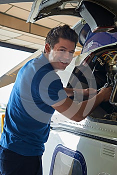 Portrait Of Male Aero Engineer Working On Helicopter In Hangar