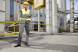 Portrait of young male architect standing arms crossed outside industry