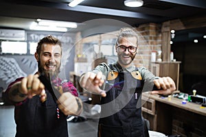 Portrait of young male barbers and hairdressers in barber shop