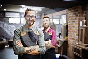 Portrait of young male barbers and hairdressers in barber shop