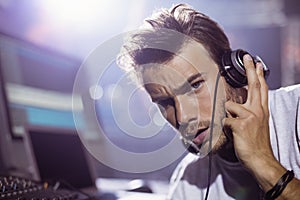 Portrait of young male dj with headphones at nightclub
