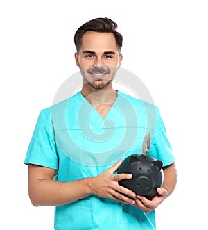 Portrait of young male doctor holding piggy