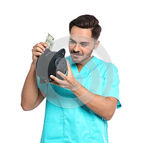 Portrait of young male doctor putting money