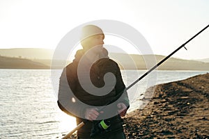 Portrait of a young male fisherman with fishing rod