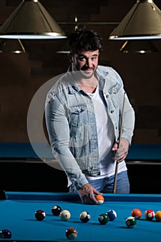 Portrait Of A Young Male Model Playing Billiards